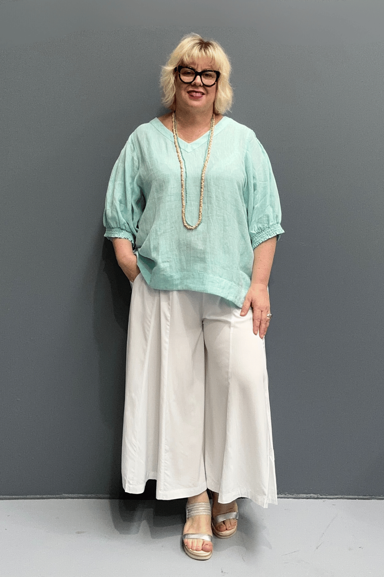 'Holly' linen top for plus size women features a high-low hem, balloon sleeves, and a comfortable fit for warm weather.