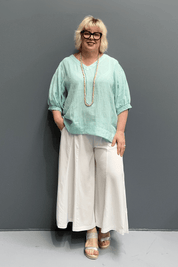 'Holly' linen top for plus size women features a high-low hem, balloon sleeves, and a comfortable fit for warm weather.