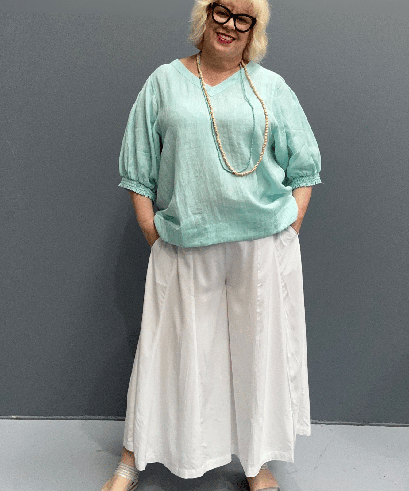 'Holly' linen top for plus size women features a high-low hem, balloon sleeves, and a comfortable fit for warm weather.