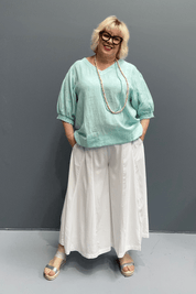 'Holly' linen top for plus size women features a high-low hem, balloon sleeves, and a comfortable fit for warm weather.