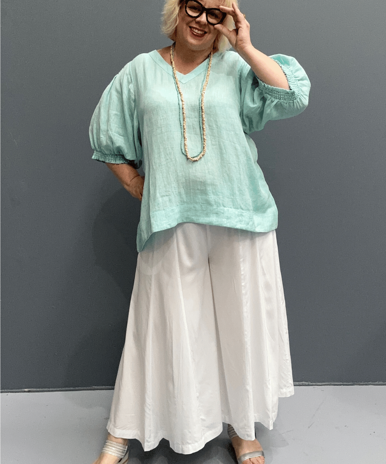 'Holly' linen top for plus size women features a high-low hem, balloon sleeves, and a comfortable fit for warm weather.