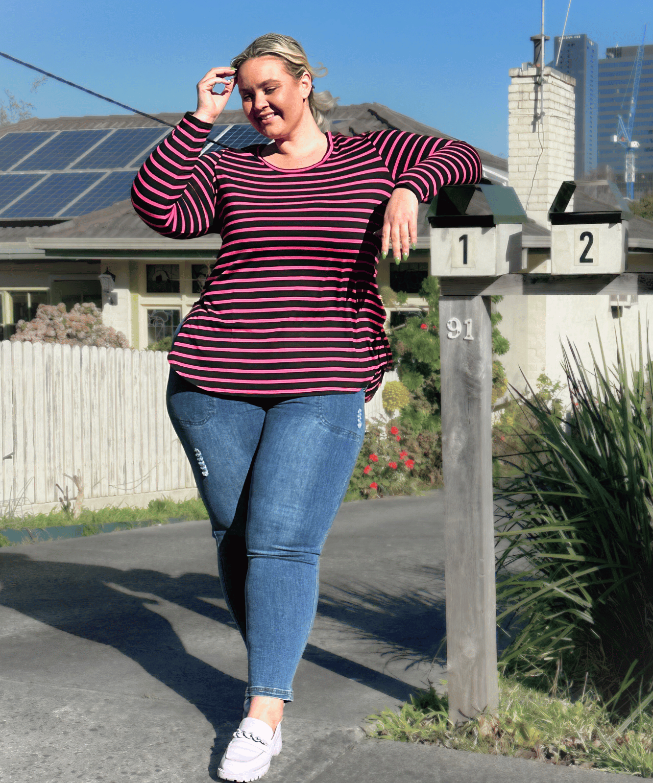 Plus-size black and pink striped long sleeve top with a stylish fit.
