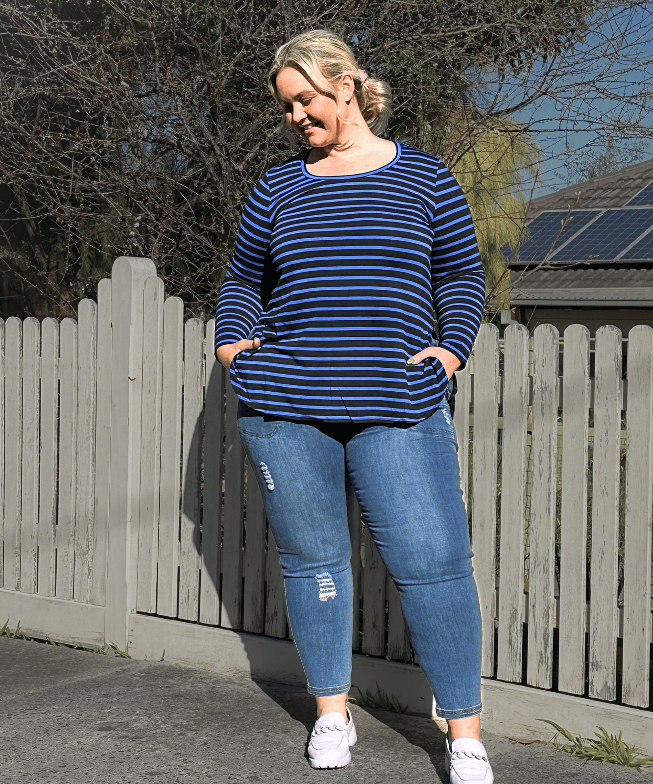 Plus-size black and blue striped long sleeve top with a stylish fit.