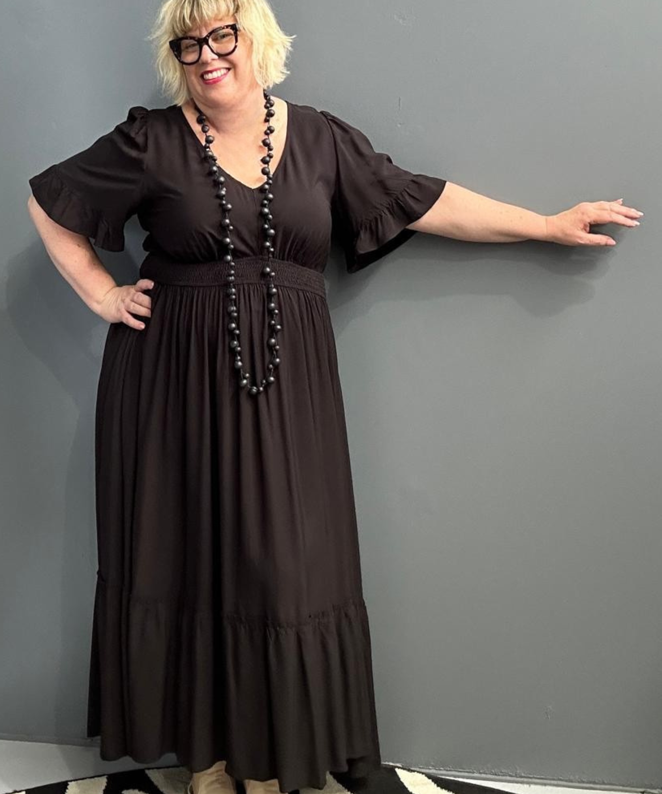 Plus-size black maxi dress with a soft, flowing silhouette.