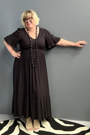 Plus-size black maxi dress with a soft, flowing silhouette.