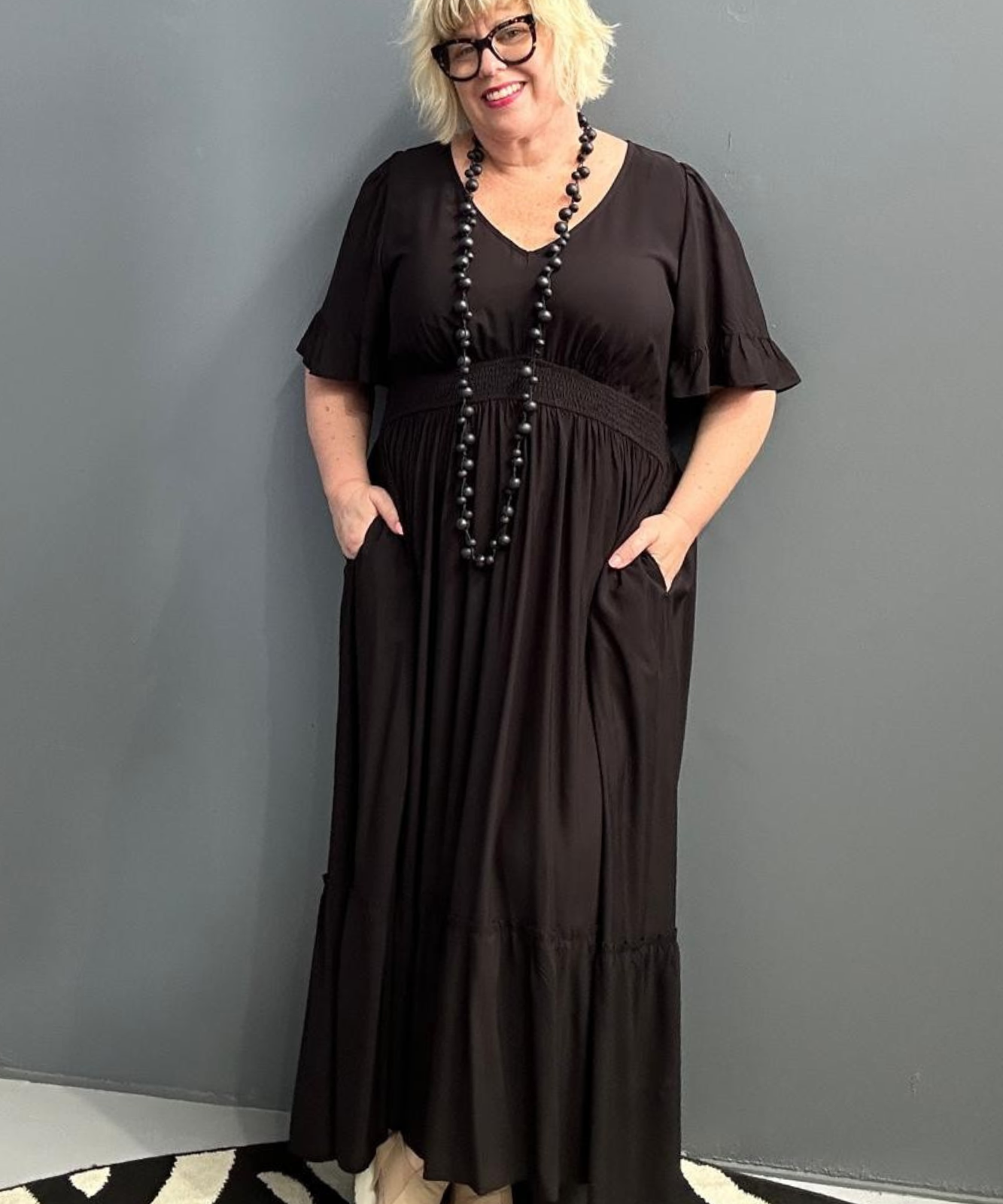 Plus-size black maxi dress with a soft, flowing silhouette.
