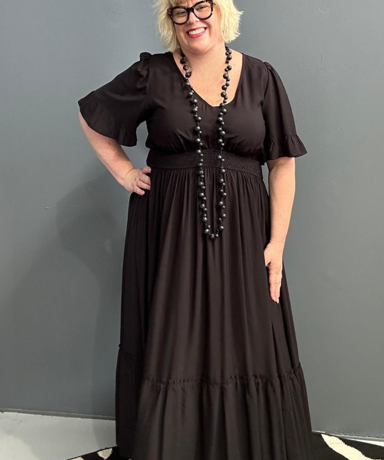 Plus-size black maxi dress with a soft, flowing silhouette.