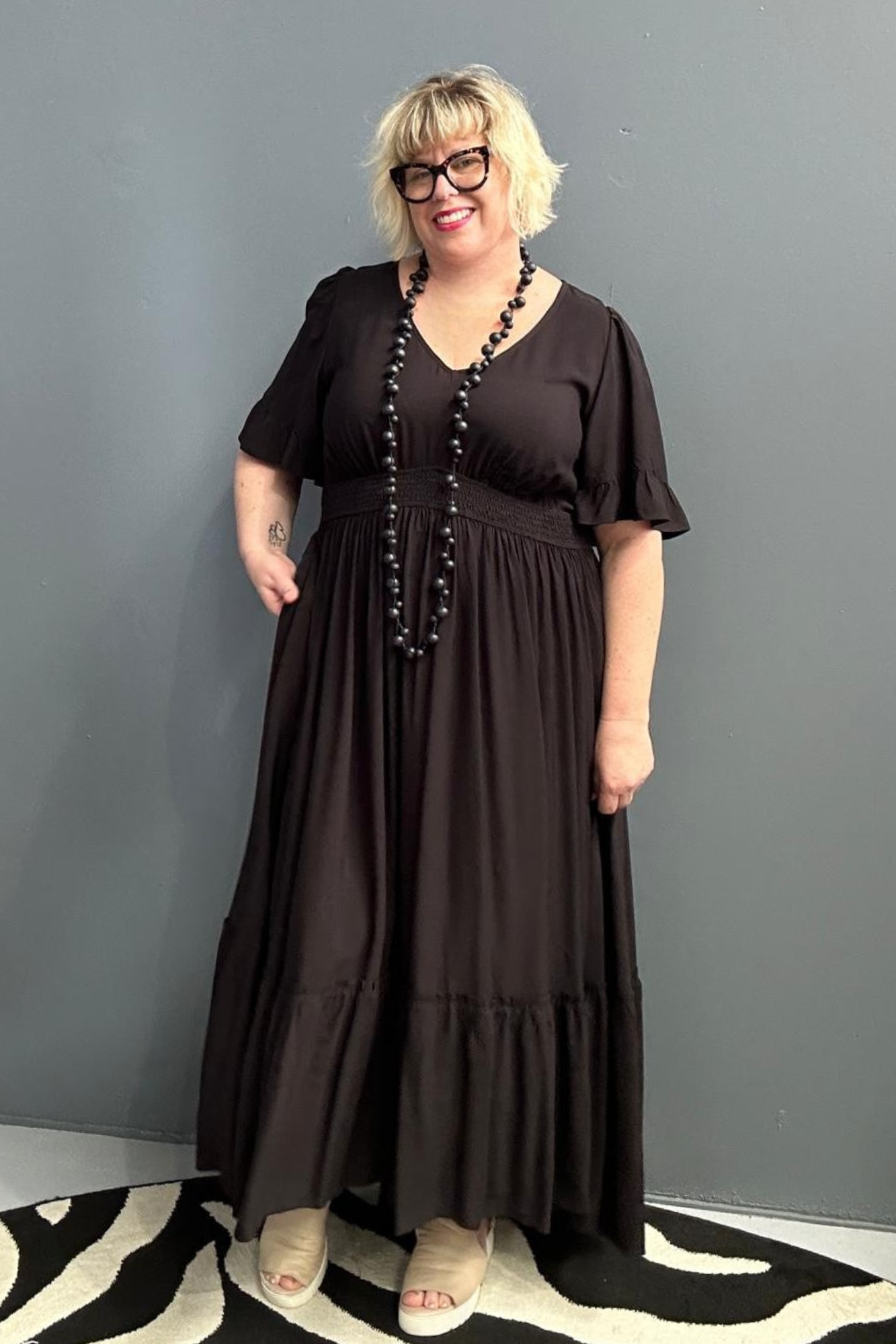 Plus-size black maxi dress with a soft, flowing silhouette.
