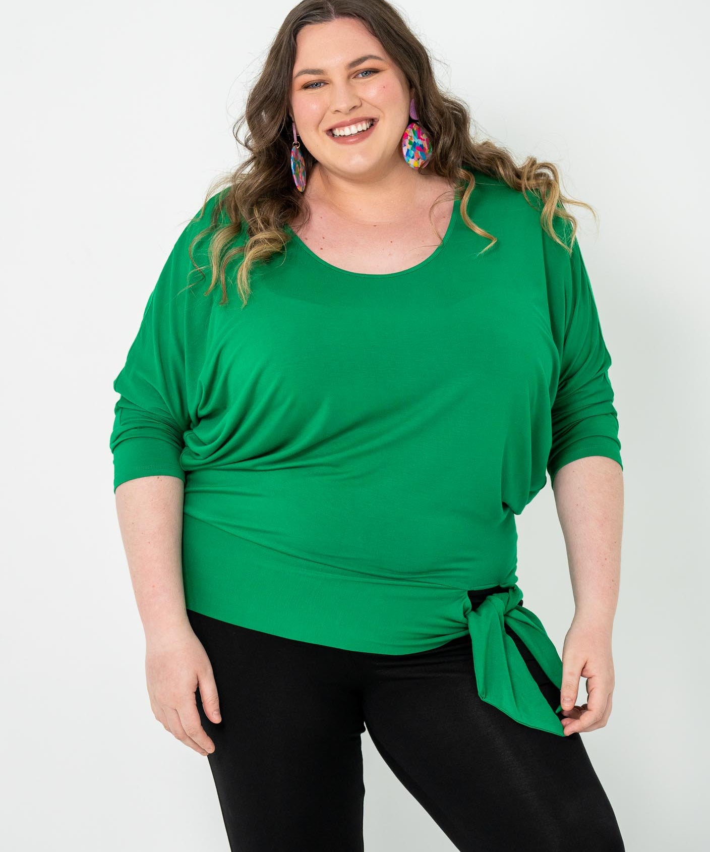 Plus-size Bat Wing Top in Green Tambourine with a stylish batwing cut and adjustable side ties for a customized fit.