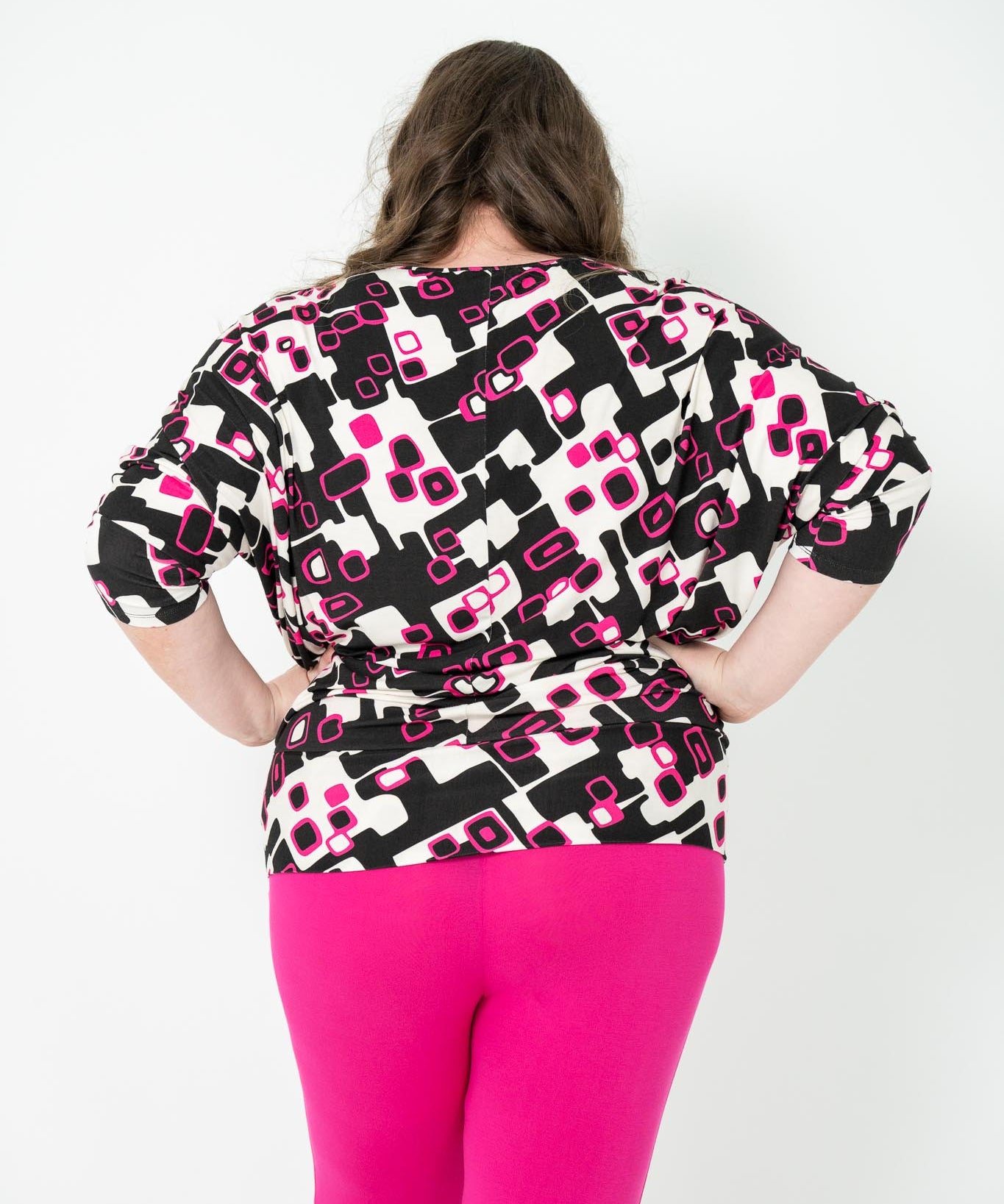 Plus-size 'GEORGIA' Bat Wing Top in pink with a modern geo square print and stylish bat wing design.