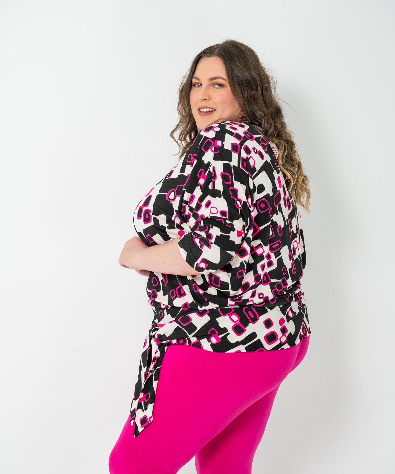 Plus-size 'GEORGIA' Bat Wing Top in pink with a modern geo square print and stylish bat wing design.