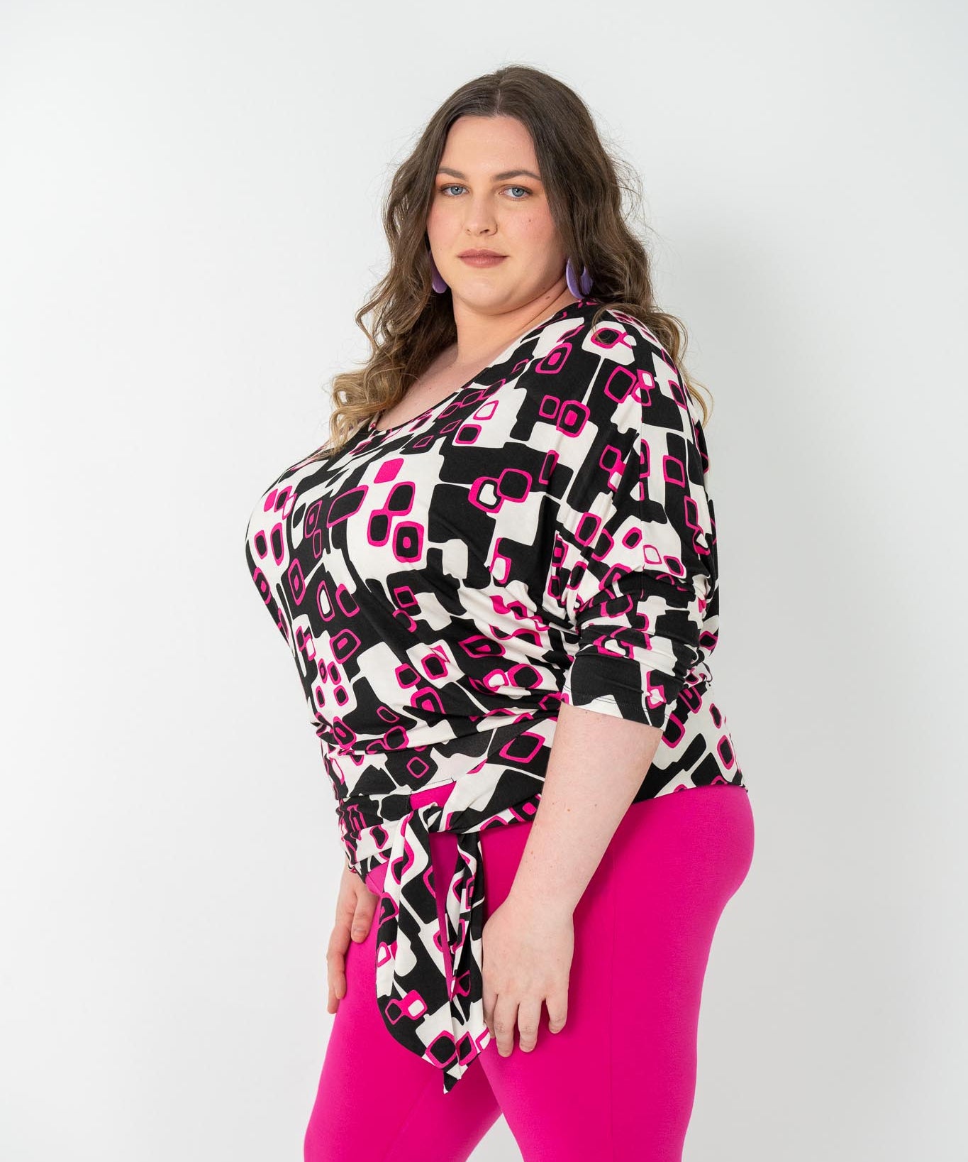 Plus-size 'GEORGIA' Bat Wing Top in pink with a modern geo square print and stylish bat wing design.