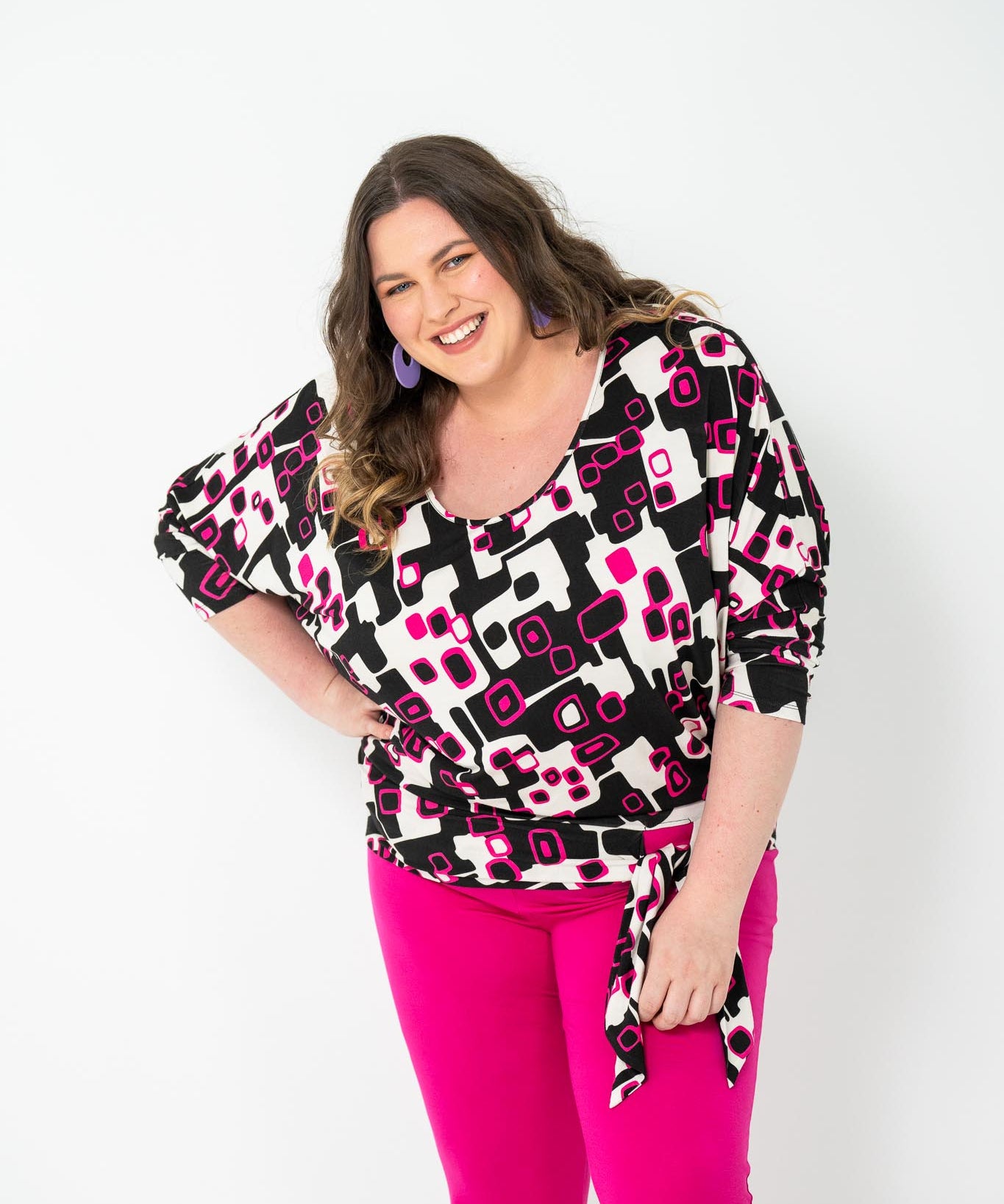 Plus-size 'GEORGIA' Bat Wing Top in pink with a modern geo square print and stylish bat wing design.