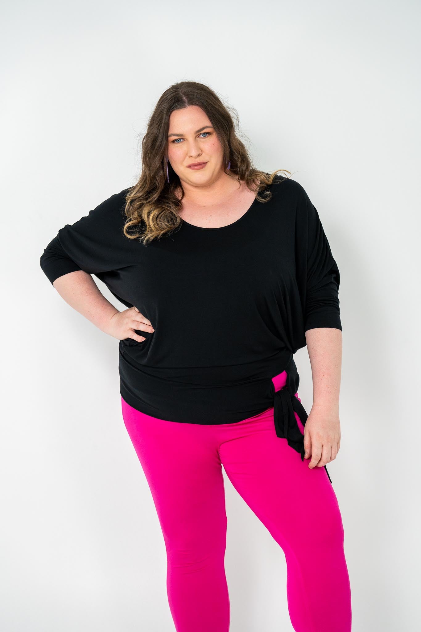 Plus-size Bat Wing Top in black with a batwing cut and adjustable side ties for a customized fit.