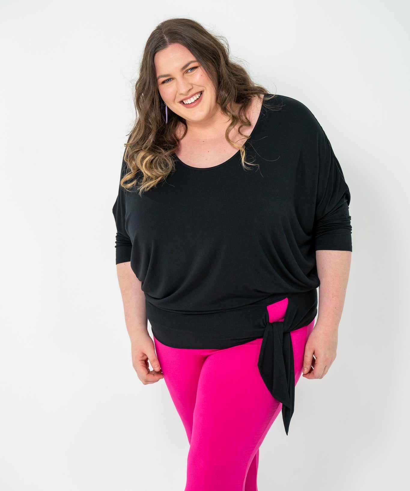 Plus-size Bat Wing Top in black with a batwing cut and adjustable side ties for a customized fit.