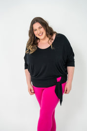 Plus-size Bat Wing Top in black with a batwing cut and adjustable side ties for a customized fit.