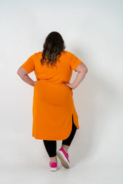 Plus size 'ALANA' T-Shirt dress in vibrant orange with a classic silhouette and pockets, perfect for layering with jackets or kimonos.