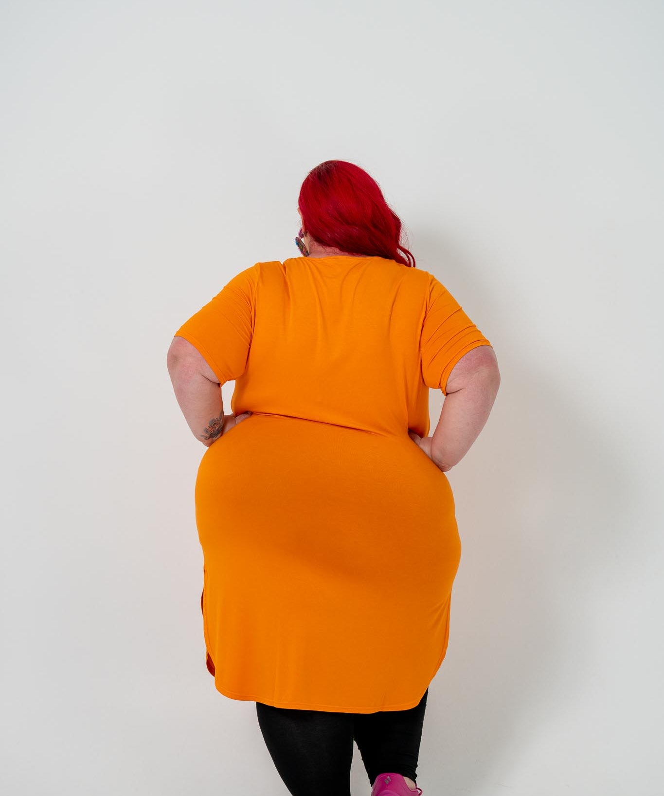 Plus size 'ALANA' T-Shirt dress in vibrant orange with a classic silhouette and pockets, perfect for layering with jackets or kimonos.