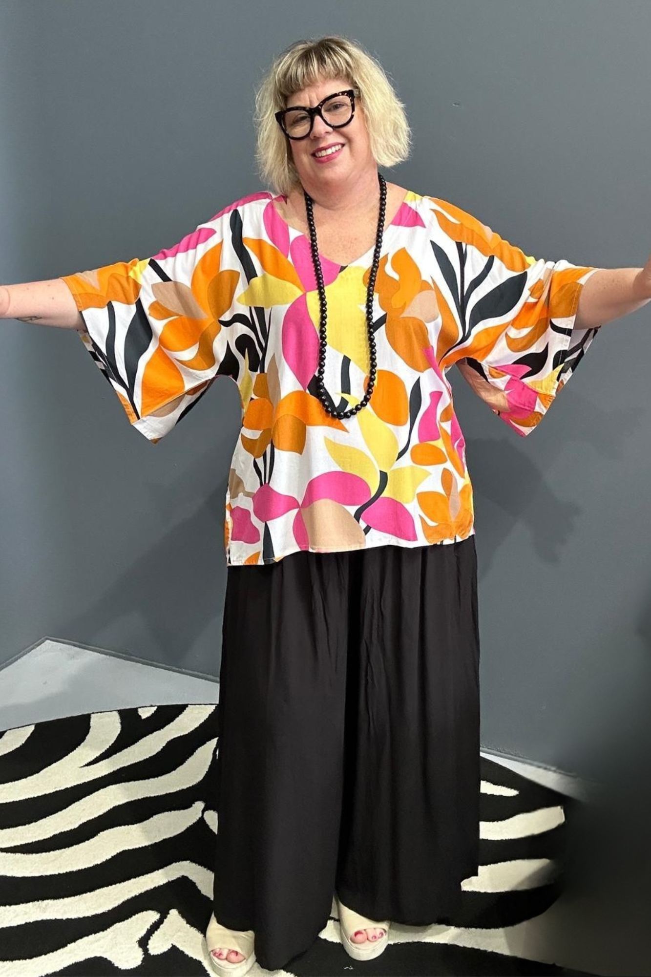 Plus-size orange top with a flowy fit and stylish drape.