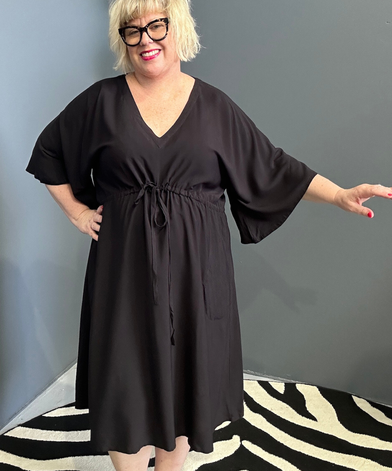 Plus-size black dress with a flattering drawstring waist.