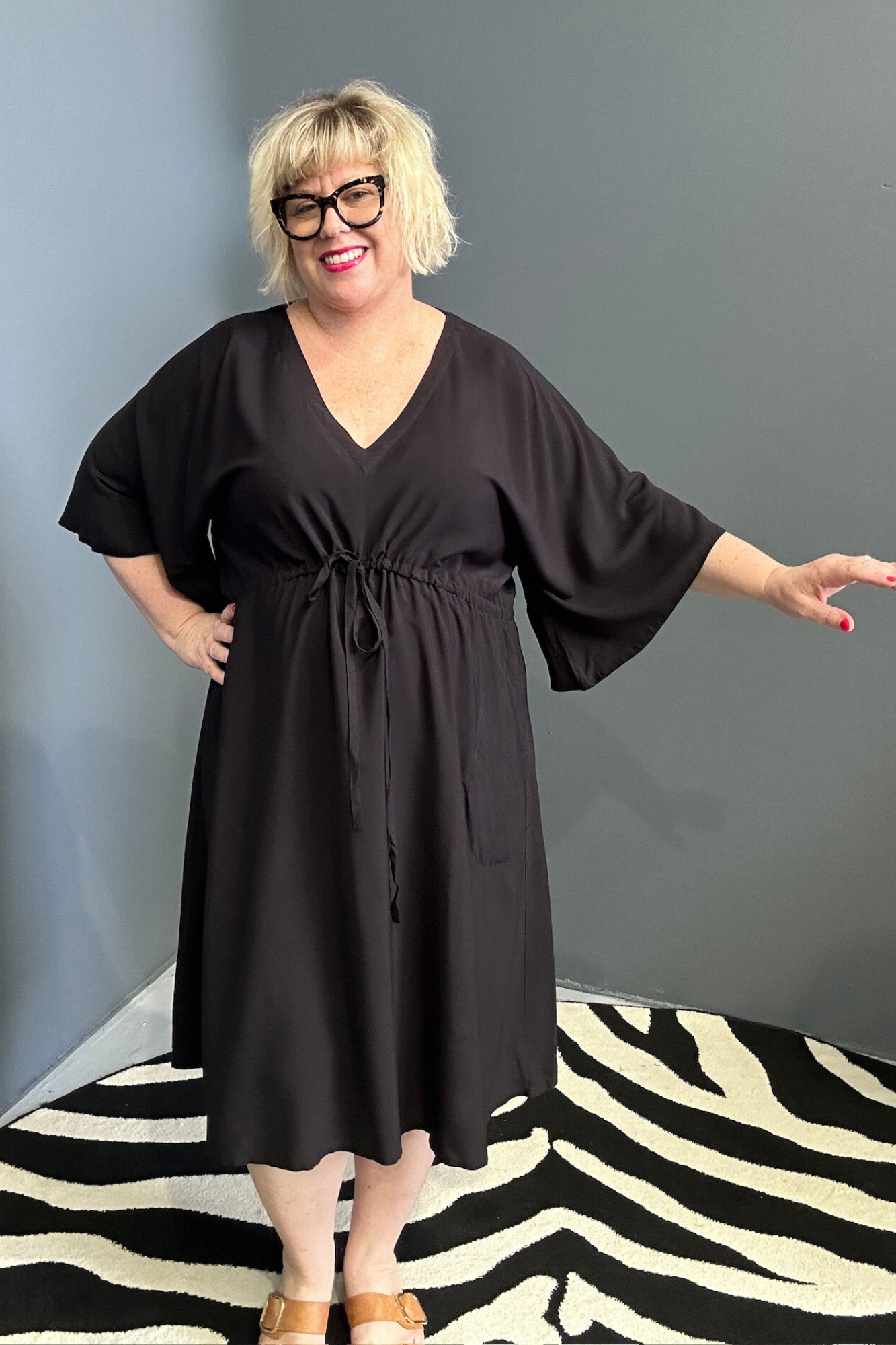 Plus-size black dress with a flattering drawstring waist.