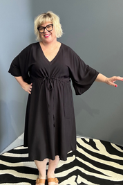 Plus-size black dress with a flattering drawstring waist.