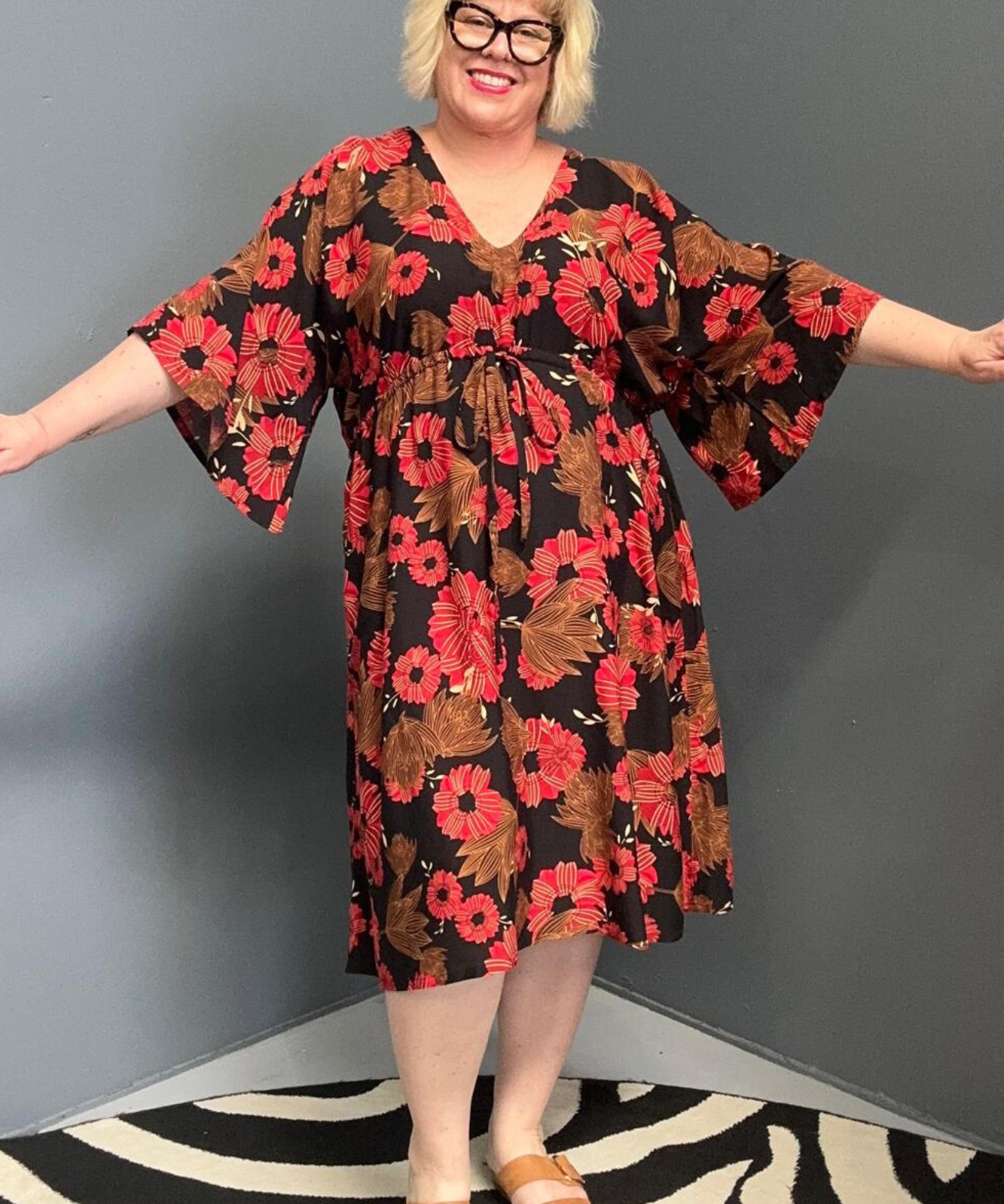 Plus-size black and red floral dress with a flattering drawstring waist.