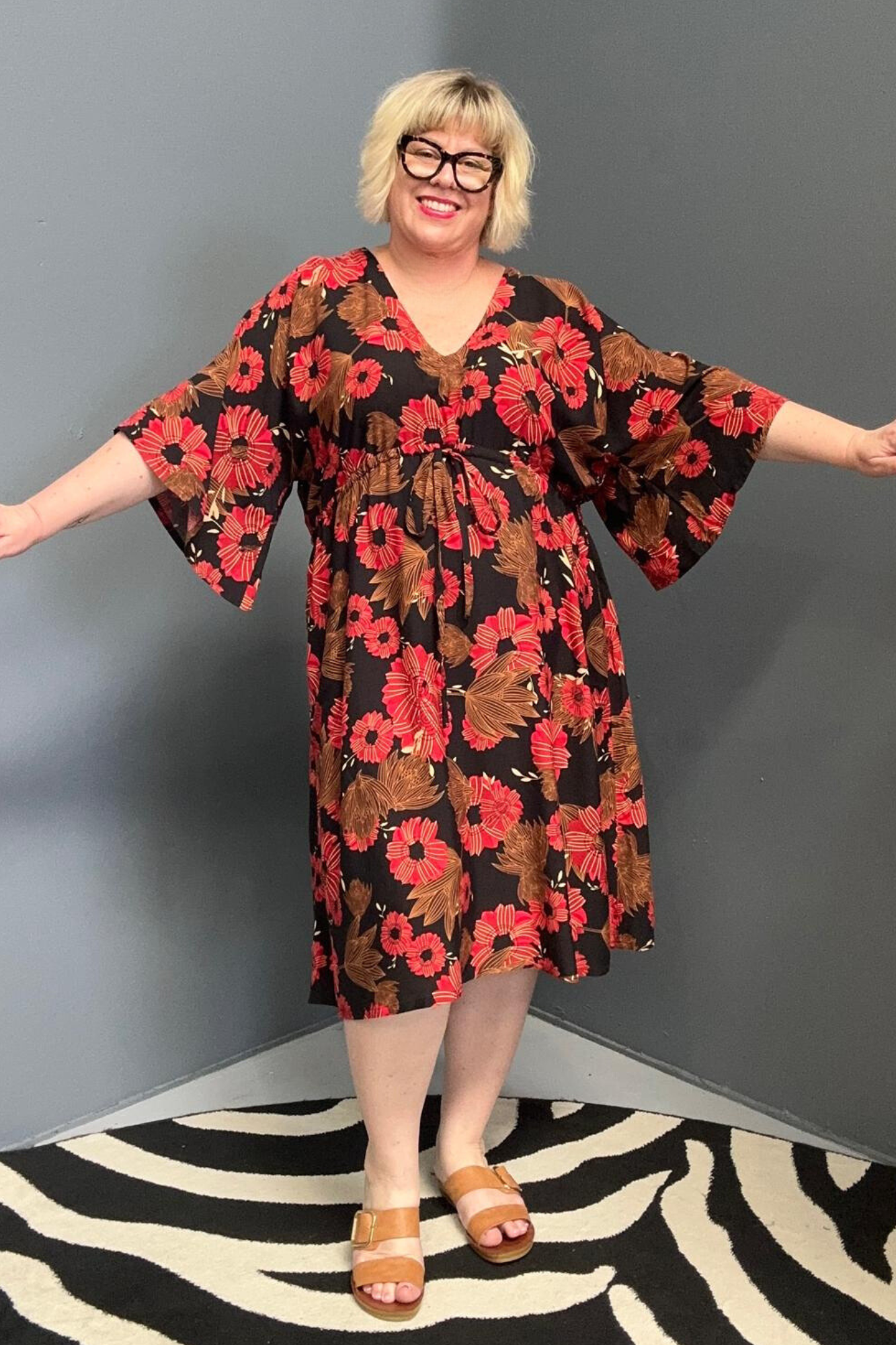 Plus-size black and red floral dress with a flattering drawstring waist.
