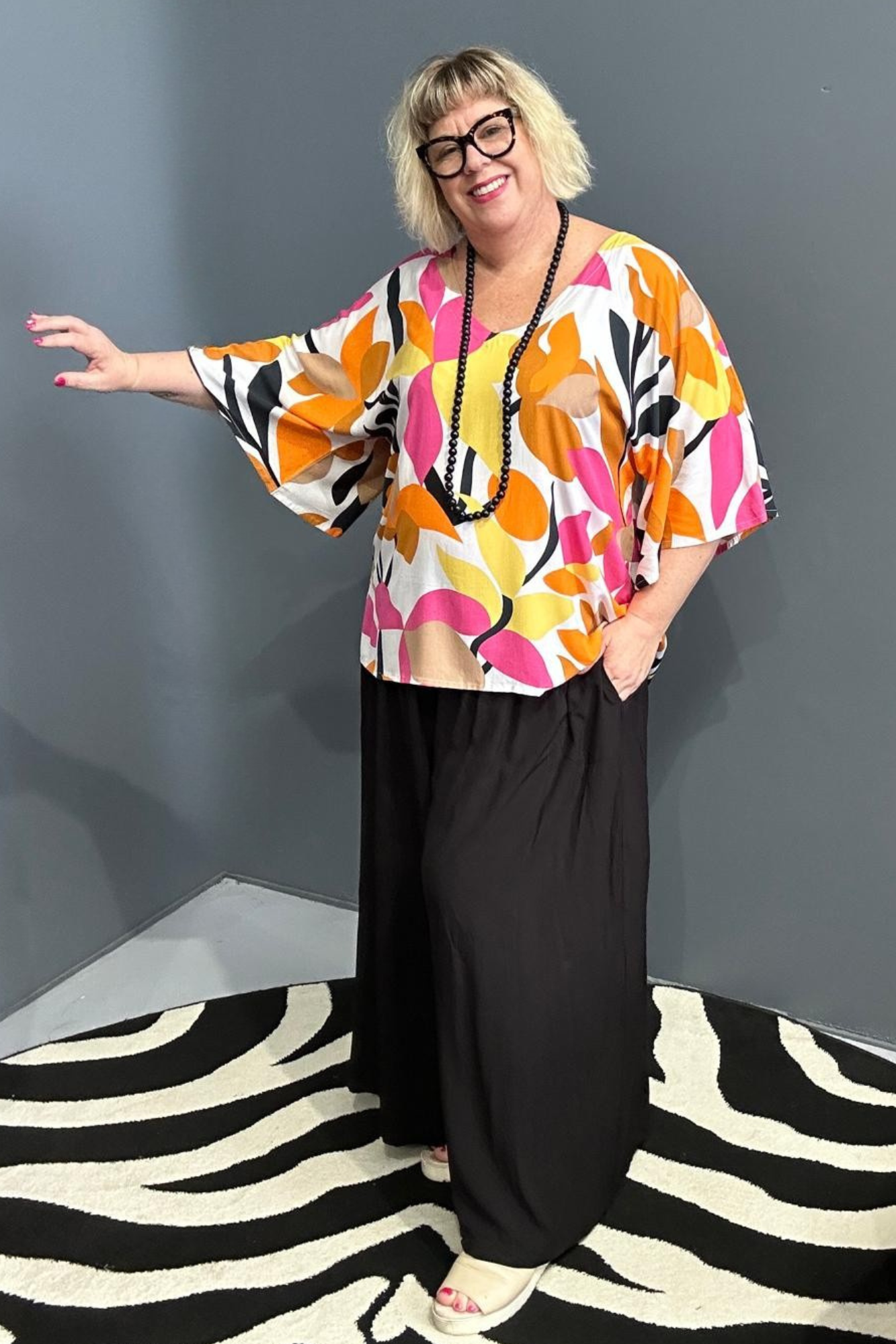 Plus-size orange top with a flowy fit and stylish drape.