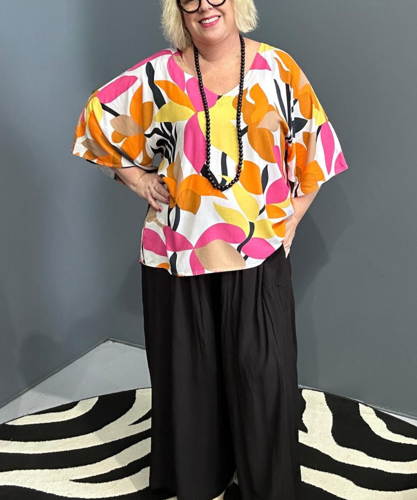 Plus-size orange top with a flowy fit and stylish drape.