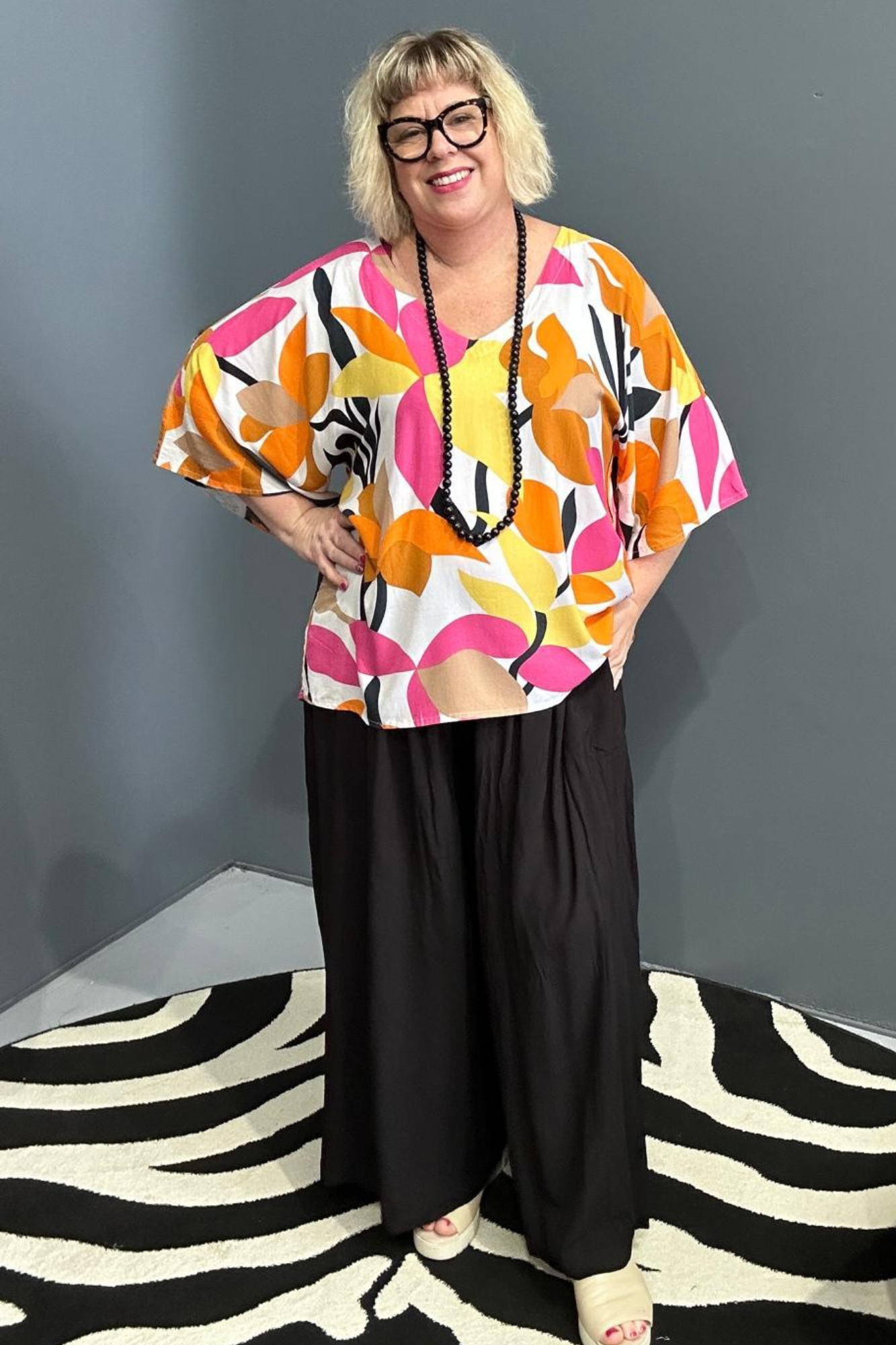 Plus-size orange top with a flowy fit and stylish drape.