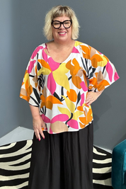 Plus-size orange top with a flowy fit and stylish drape.