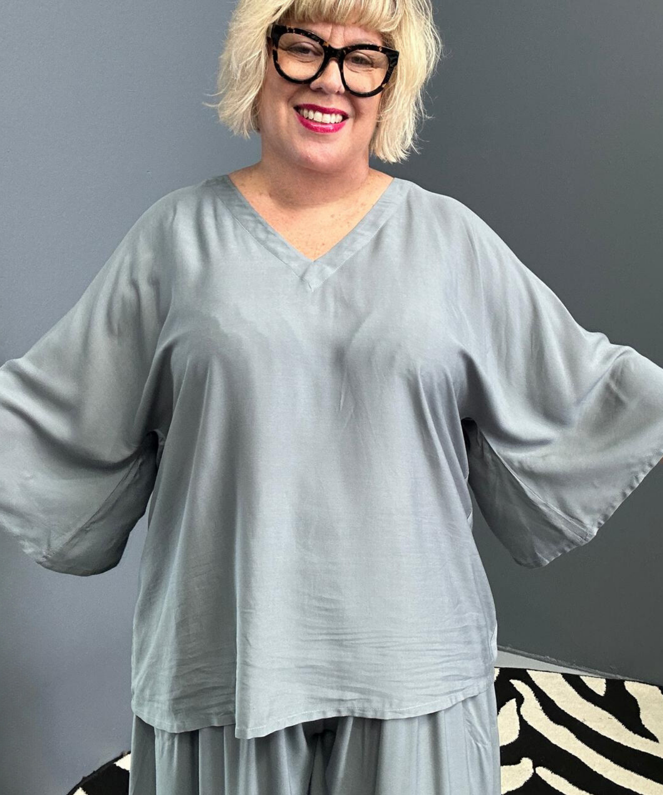 Plus-size sage green top with a stylish, flowy fit.