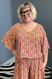Plus-size orange swirl top with a stylish, flowy fit.