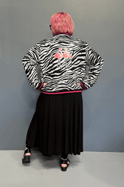 Trendy plus size bomber jacket with bamboo lining, rainproof fabric, cuff detailing, and sequined flamingos on the back.