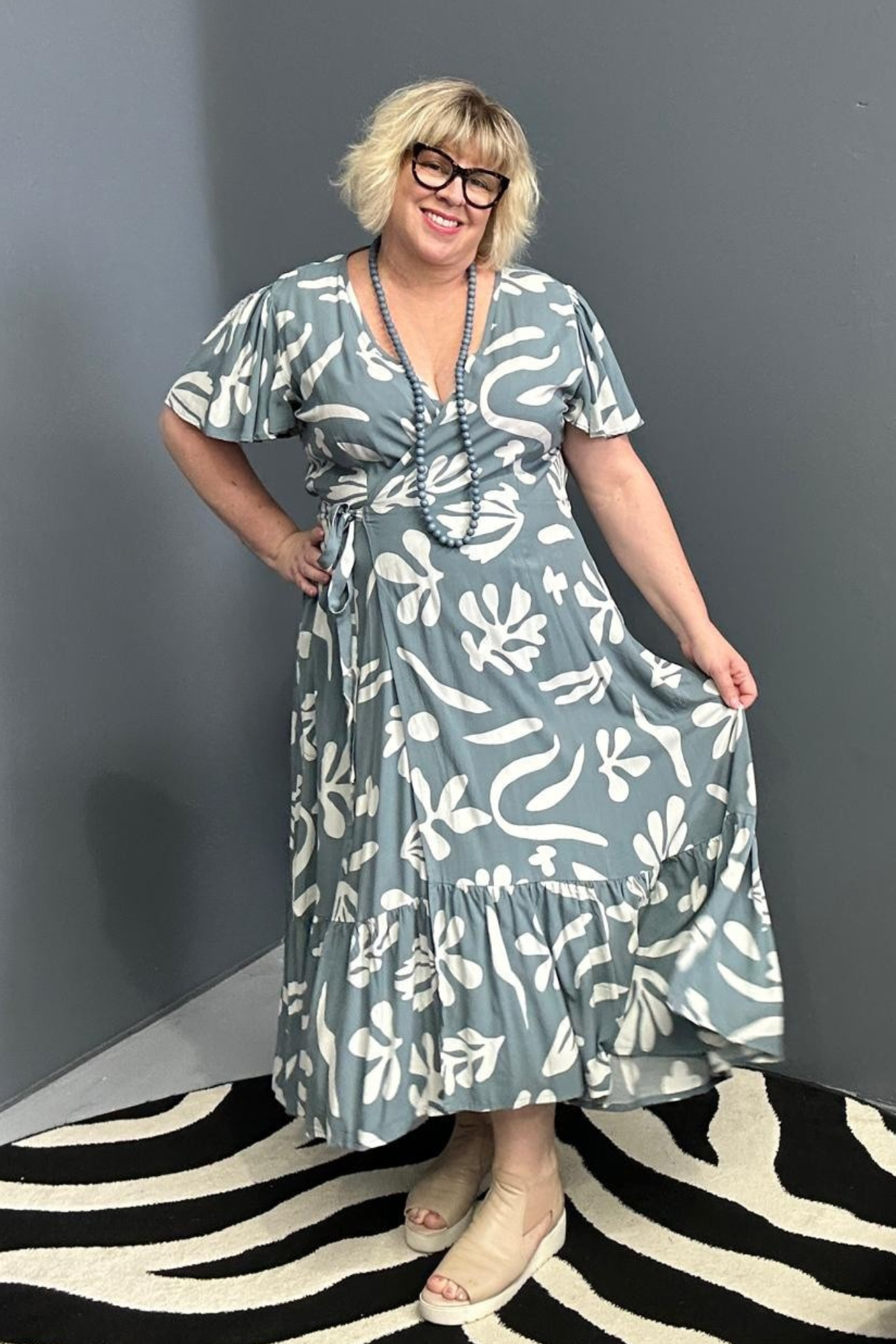 Flattering plus-size wrap dress in grey and creme tones.