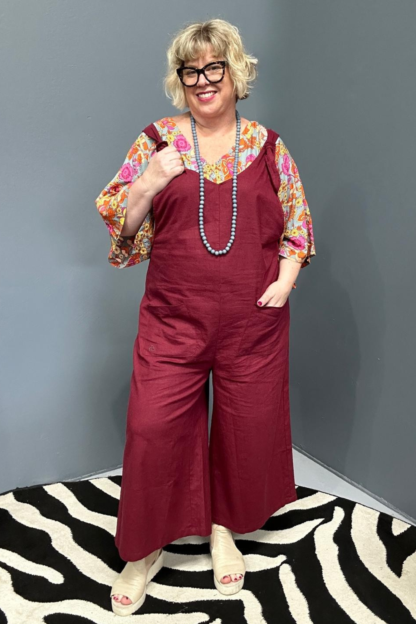 Front view of a plus-size woman wearing the 'BILLIE' stretch linen overalls in plum – relaxed fit with adjustable straps and a flattering design for curvy women.