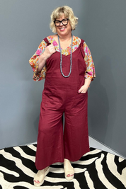 Front view of a plus-size woman wearing the 'BILLIE' stretch linen overalls in plum – relaxed fit with adjustable straps and a flattering design for curvy women.