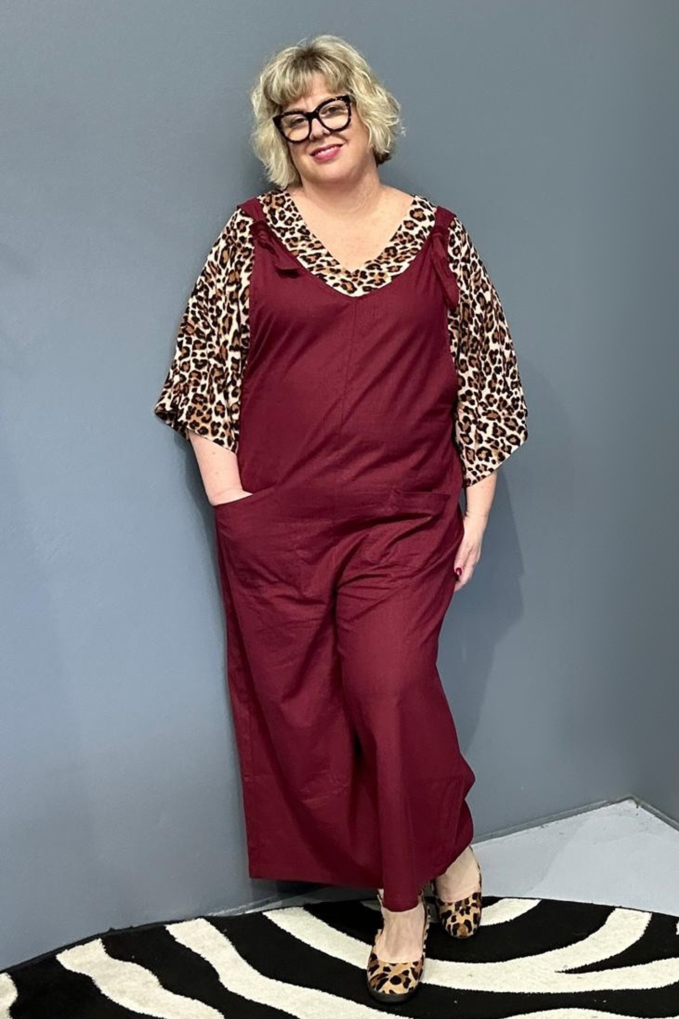 Front view of a plus-size woman wearing the 'BILLIE' stretch linen overalls in plum – relaxed fit with adjustable straps and a flattering design for curvy women.