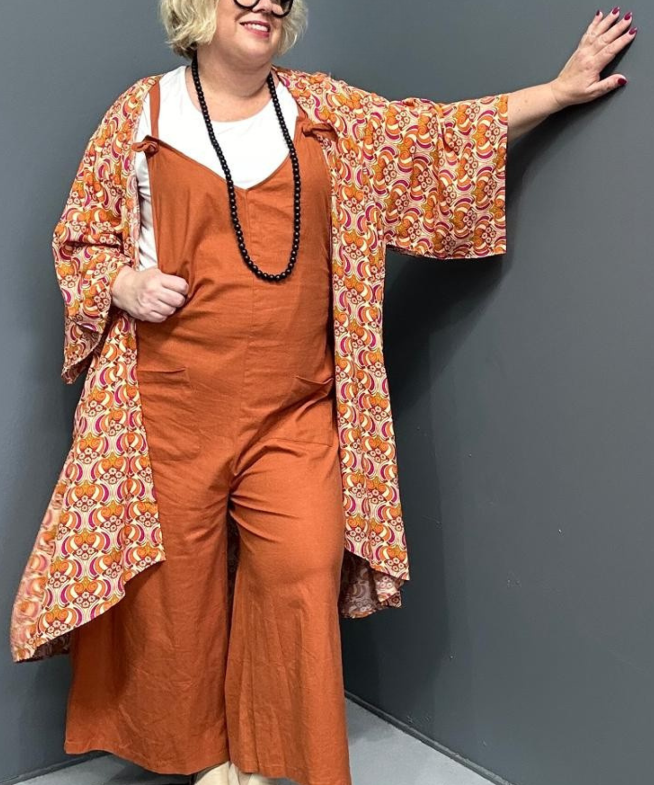 Front view of a plus-size woman wearing the 'BILLIE' stretch linen overalls in rust – relaxed fit with adjustable straps and a flattering design for curvy women