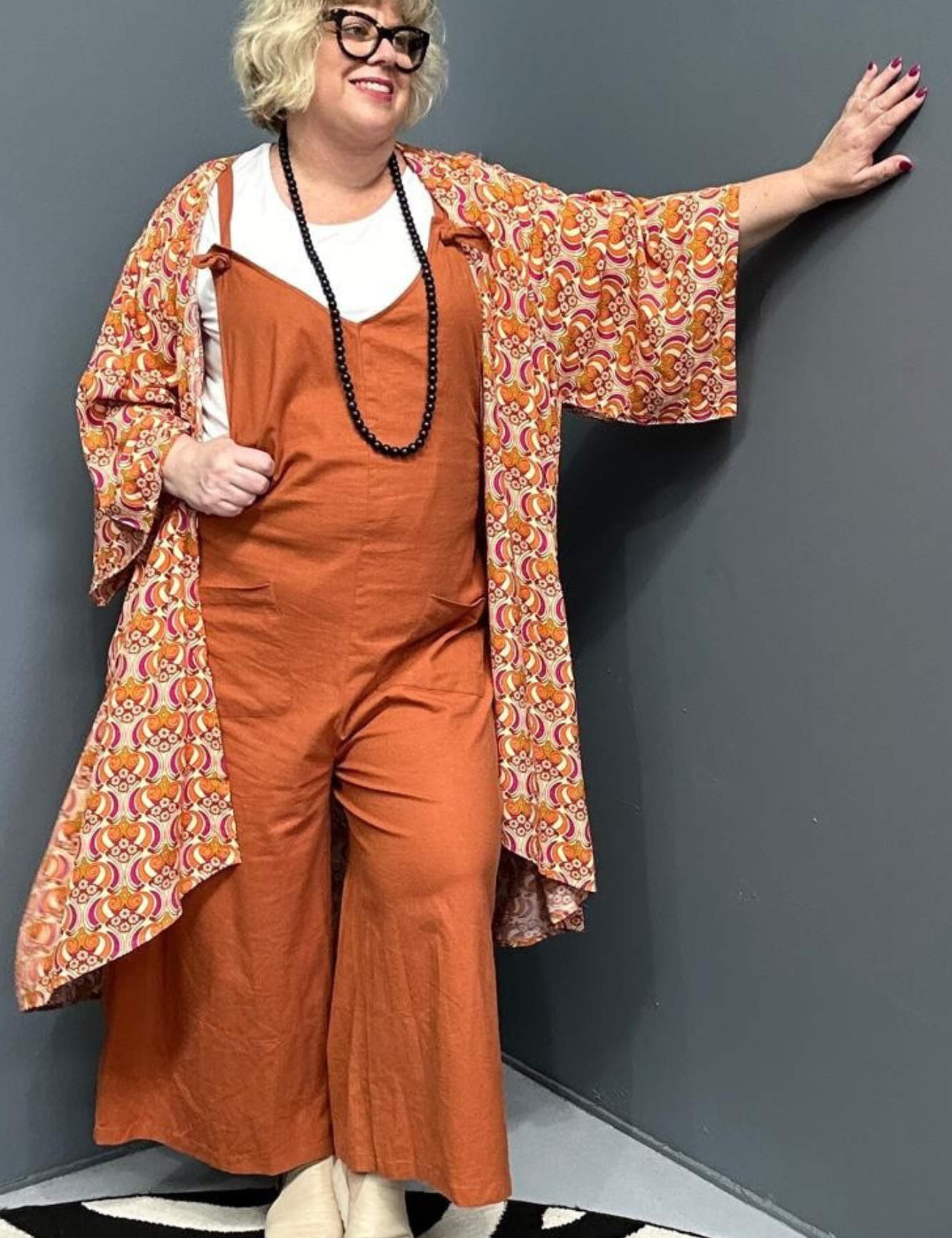 Front view of a plus-size woman wearing the 'BILLIE' stretch linen overalls in rust – relaxed fit with adjustable straps and a flattering design for curvy women