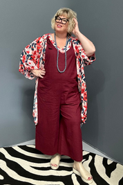 Front view of a plus-size woman wearing the 'BILLIE' stretch linen overalls in plum – relaxed fit with adjustable straps and a flattering design for curvy women.