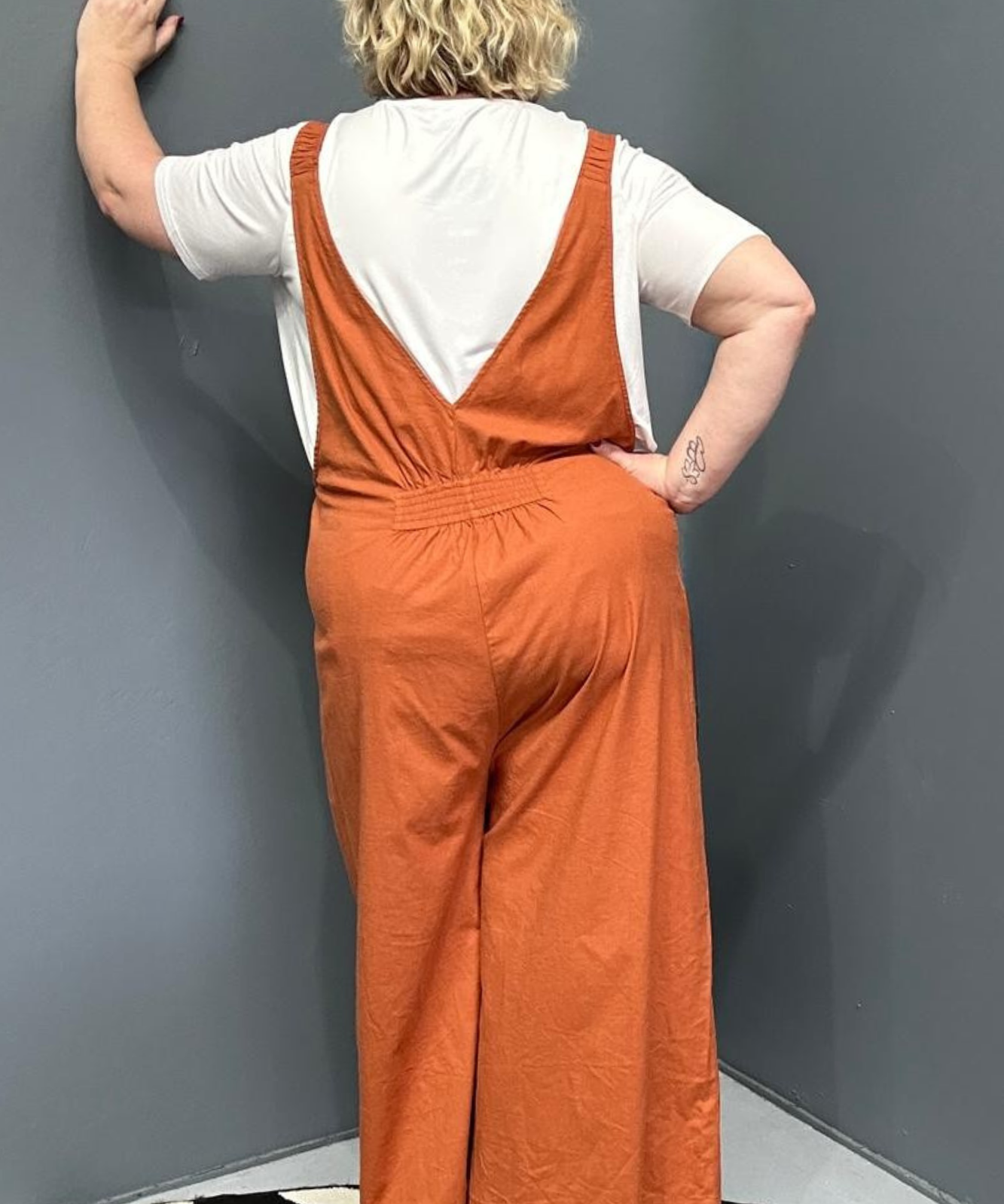 Front view of a plus-size woman wearing the 'BILLIE' stretch linen overalls in rust – relaxed fit with adjustable straps and a flattering design for curvy women