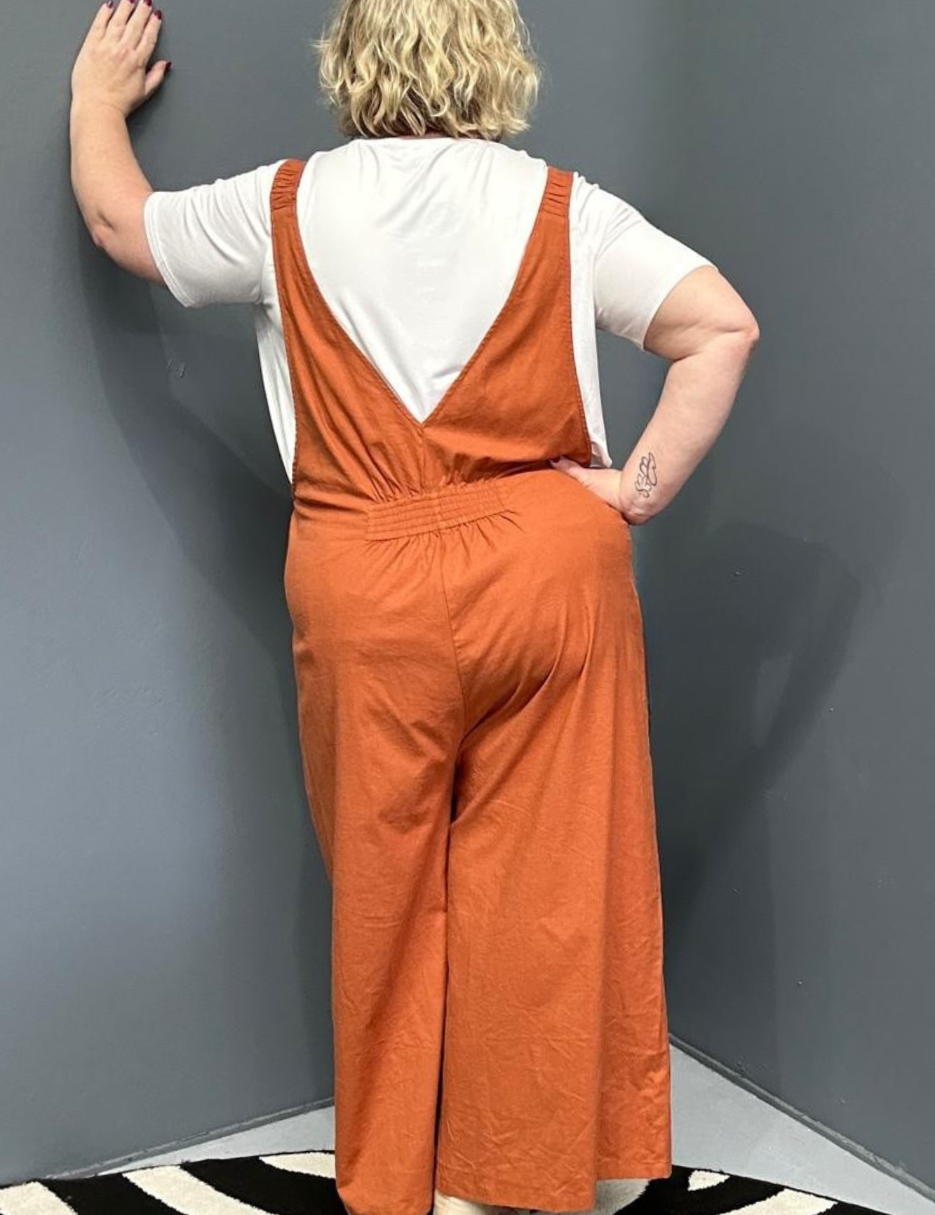 Front view of a plus-size woman wearing the 'BILLIE' stretch linen overalls in rust – relaxed fit with adjustable straps and a flattering design for curvy women