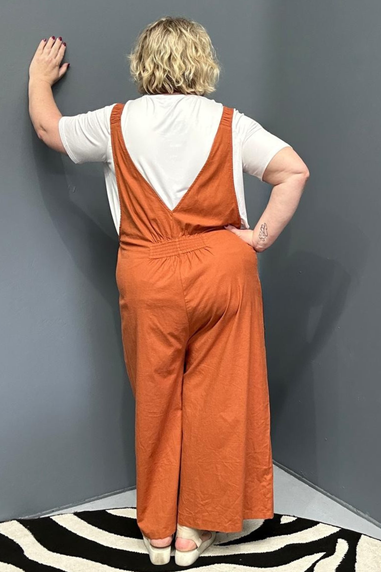 Front view of a plus-size woman wearing the 'BILLIE' stretch linen overalls in rust – relaxed fit with adjustable straps and a flattering design for curvy women