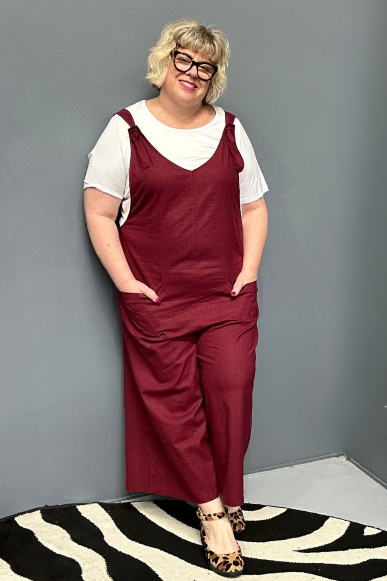 Front view of a plus-size woman wearing the 'BILLIE' stretch linen overalls in plum – relaxed fit with adjustable straps and a flattering design for curvy women.
