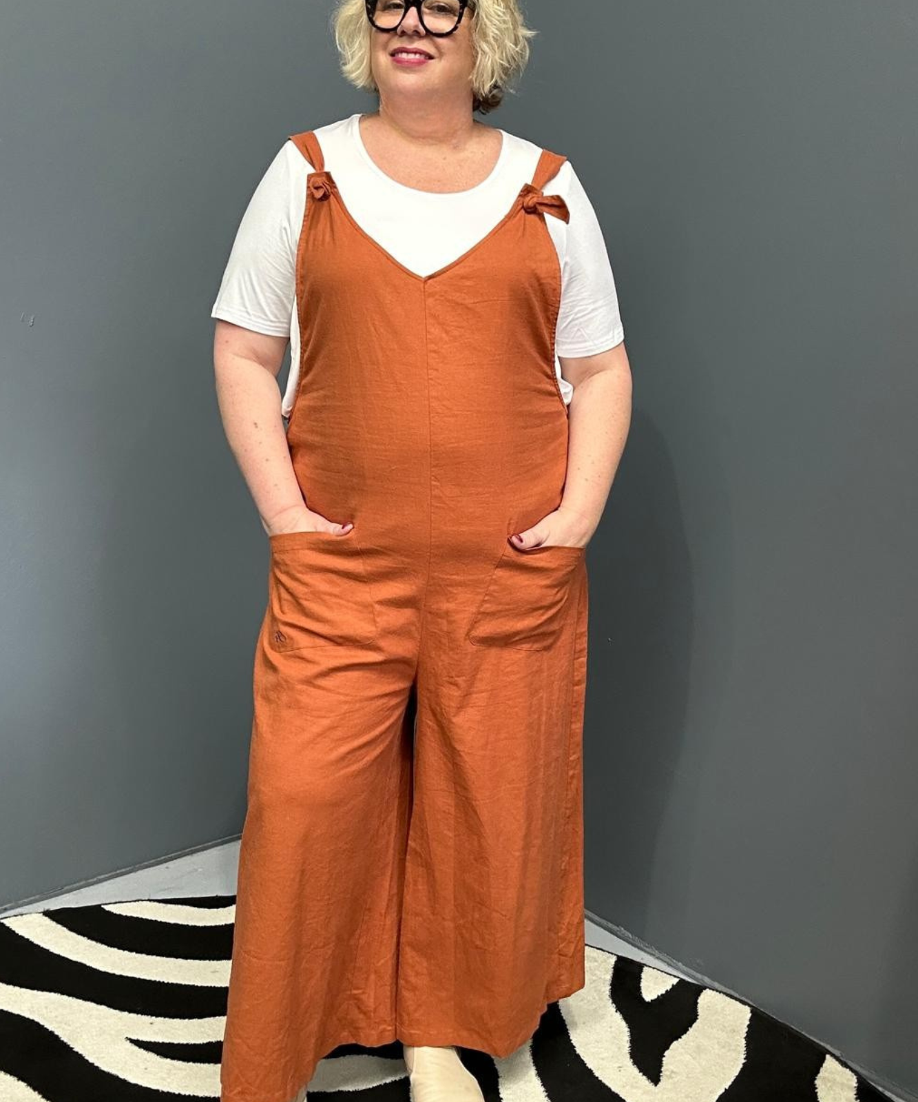 Front view of a plus-size woman wearing the 'BILLIE' stretch linen overalls in rust – relaxed fit with adjustable straps and a flattering design for curvy women
