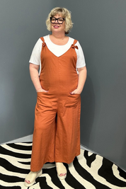 Front view of a plus-size woman wearing the 'BILLIE' stretch linen overalls in rust – relaxed fit with adjustable straps and a flattering design for curvy women