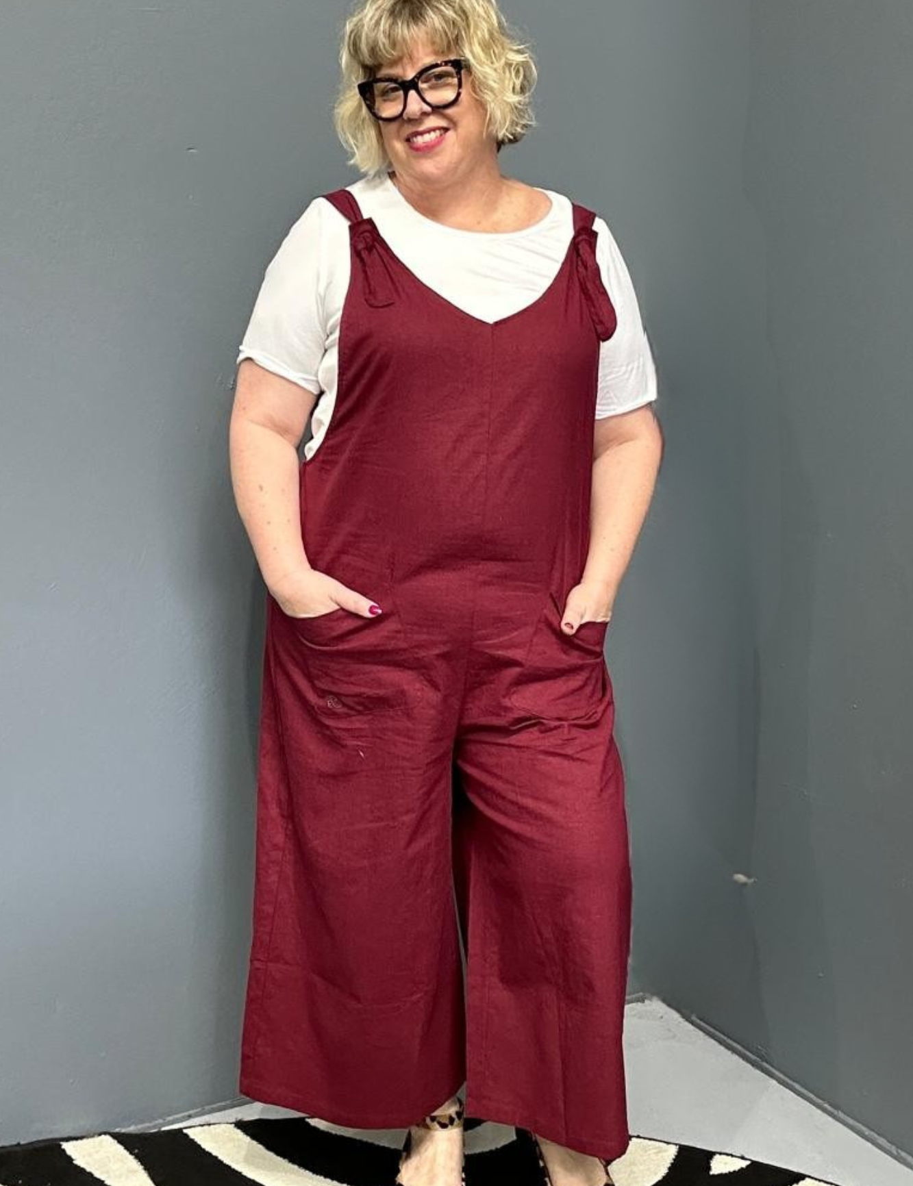 Front view of a plus-size woman wearing the 'BILLIE' stretch linen overalls in plum – relaxed fit with adjustable straps and a flattering design for curvy women.
