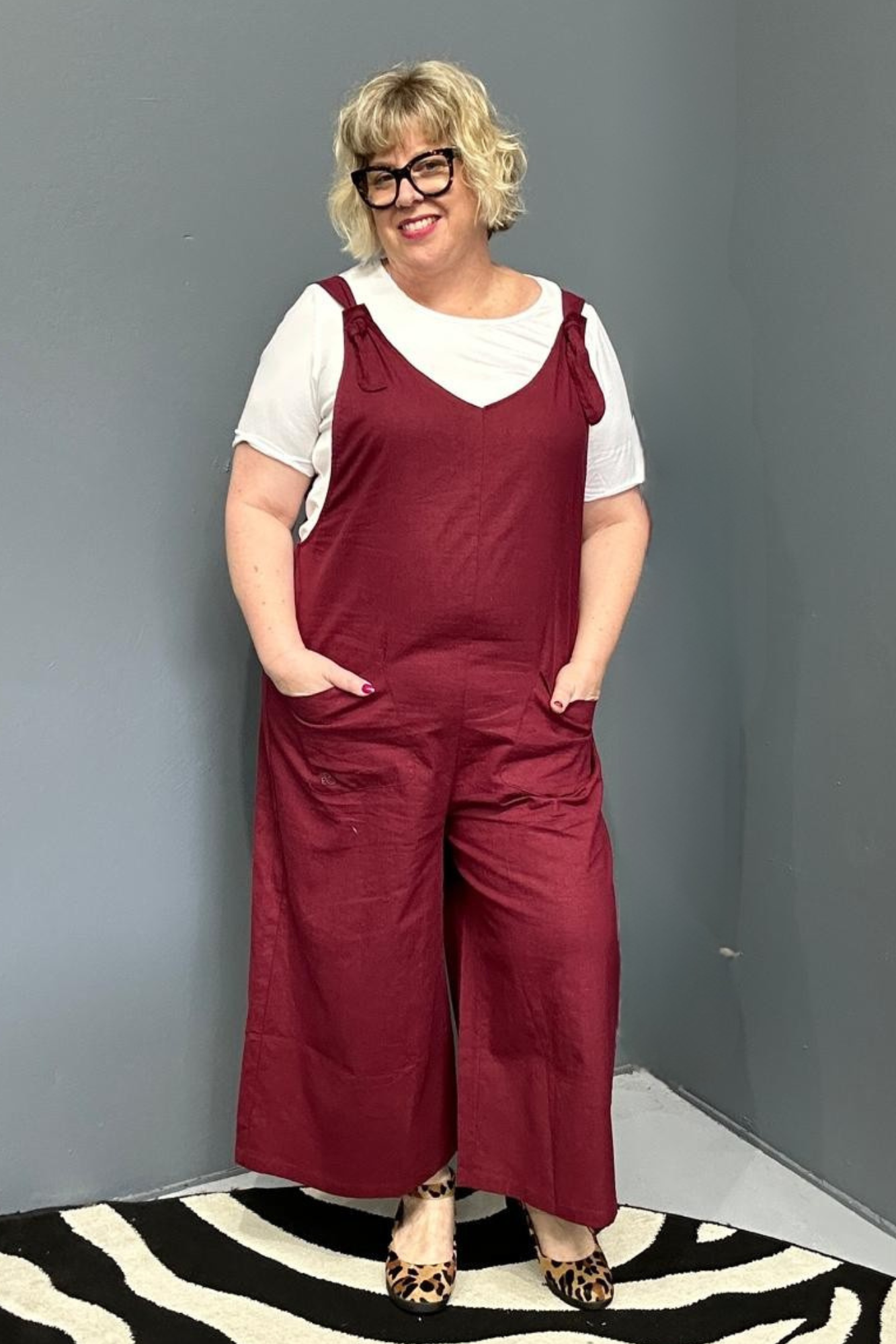 Front view of a plus-size woman wearing the 'BILLIE' stretch linen overalls in plum – relaxed fit with adjustable straps and a flattering design for curvy women.